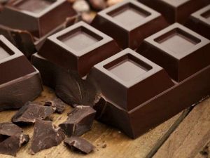 Razlomljena čokolada na leseni podlagi