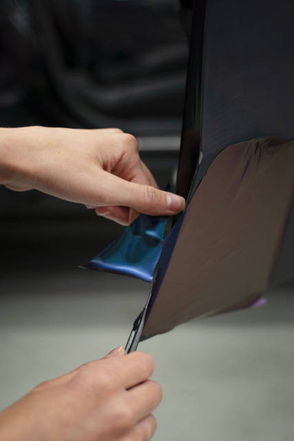 Oseba odstranjuje nalepke za avto