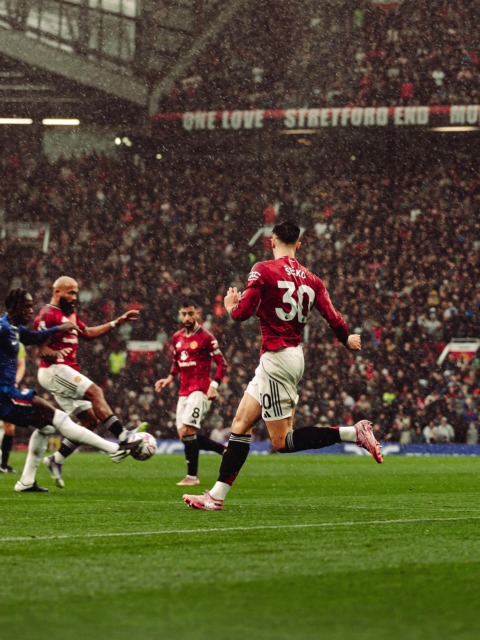 Benjamin Šeško v dresu Manchester United med akcijo v kazenskem prostoru na tekmi v dežju