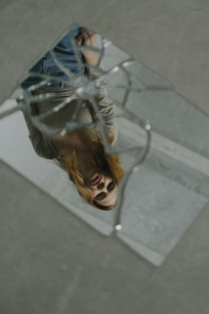 Razbito steklo z odsevom osebe