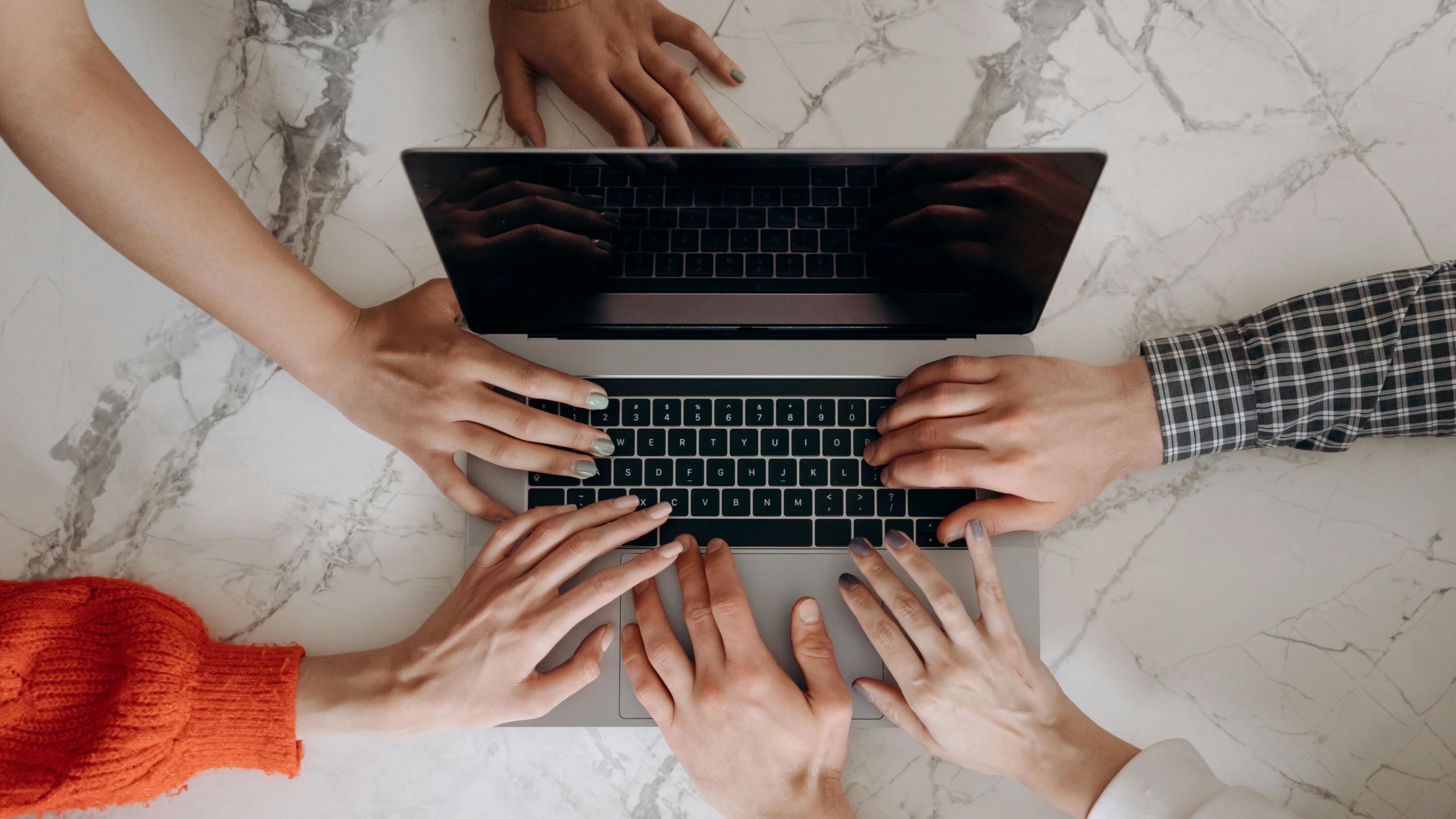 Deljenje informacij predstavljeno z rokami ob prenosniku