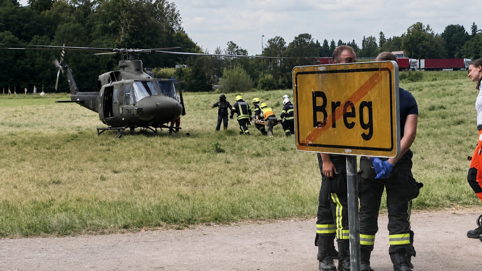 Helikopter in reševalci na travniku na Bregu pri Komendi med intervencijo po hudi nesreči najstnika.