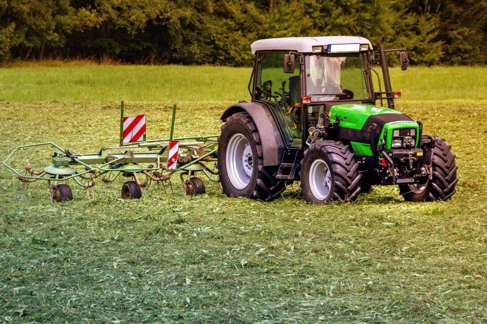 Traktor orje po njivi. Dela s traktorjem.