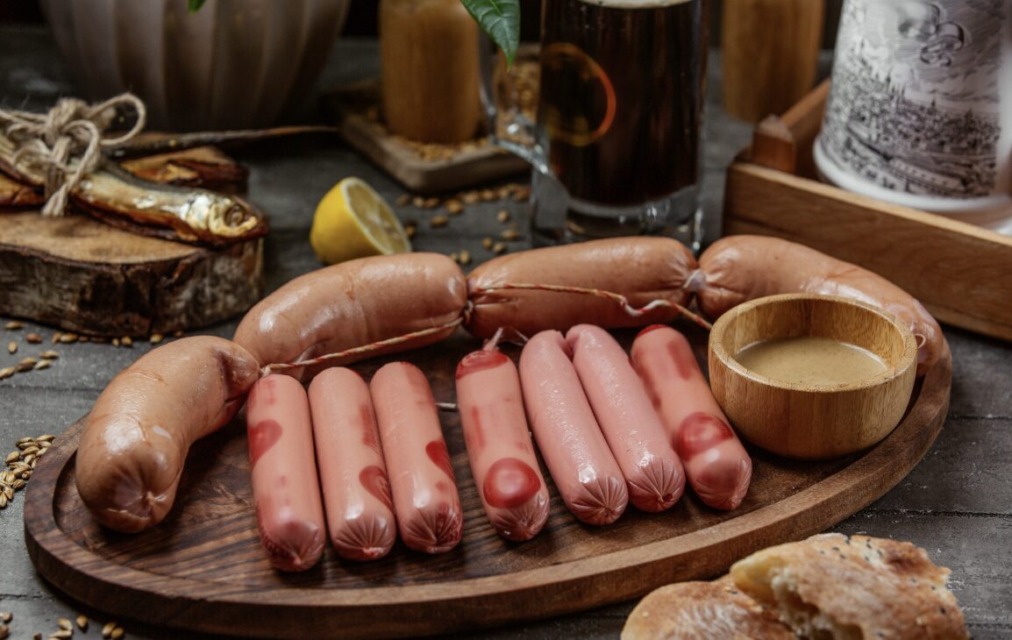 Hrenovke in klobase na leseni površini