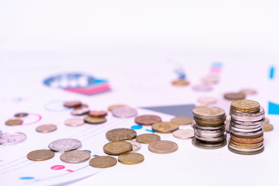 Kovanci na finančnih dokumentih, ki ponazarjajo izračun davka na dediščino