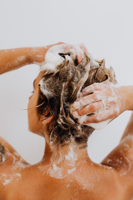 Prhljaj kaj pomaga, oseba pere lase z  šamponom za preprečevanje